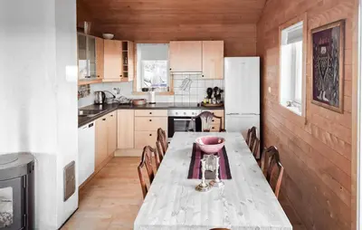 a kitchen with a table with chairs and a refrigerator at 3 Bedroom Stunning Home In Tansøy in Tansøy