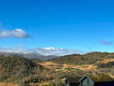 a house on a hill with mountains in the background at Well-Equipped Cabin Near Rauland Alpine Centre in Rauland
