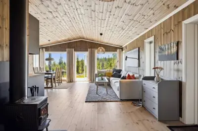 a living room with a couch and a table at Family Cabin BUDOR - 60 MIN FROM OSL - Alpine Cross Country Skiing in Løten