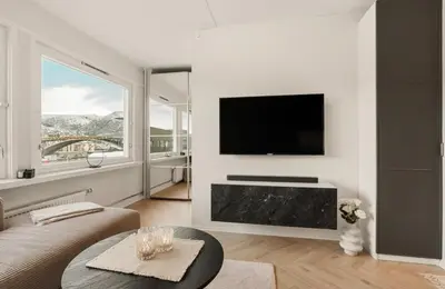 a living room with a flat screen tv on a wall at Modern and cozy apartment ONLY 5 minutes from City Center in Bergen
