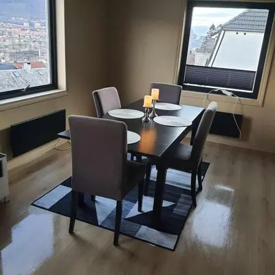 a dining room with a table and chairs and a window at Great apartment overlooking Bergen in Bergen
