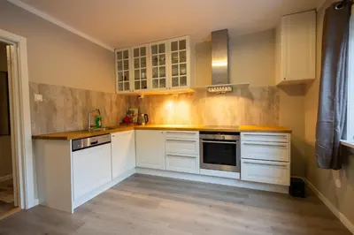a kitchen with white cabinets and a sink at Spacious Apartment - City Center in Stryn
