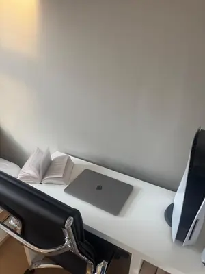 a desk with a laptop computer and books on it at Stylish 2BR with Patio and Smart TV - 10 min to Bryggen in Bergen
