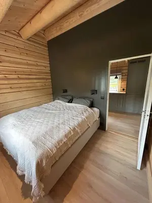 a bedroom with a bed in a wooden wall at Gunhild-stugu i Jotunheimen