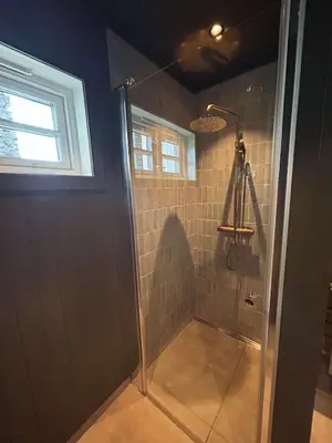 a shower with a glass door in a bathroom at Gunhild-stugu i Jotunheimen