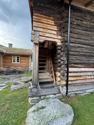a log cabin with a staircase on the side of it at Gunhild-stugu i Jotunheimen