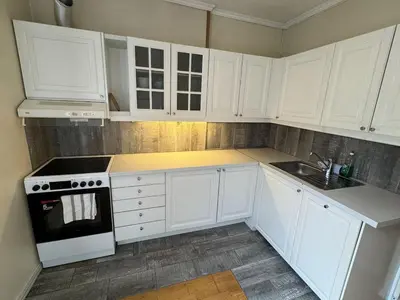 a white kitchen with white cabinets and a sink at Cozy Studio in Lademoen, Trondheim in Trondheim