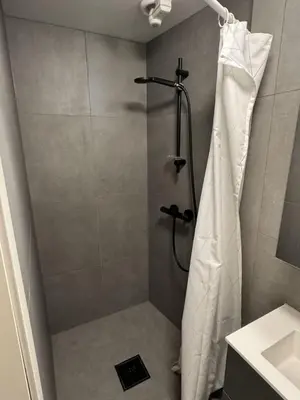 a shower with a shower curtain in a bathroom at Modern and central apartment in Trondheim in Trondheim