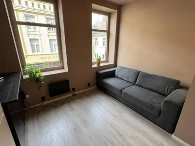 a living room with a couch and two windows at Modern and central apartment in Trondheim in Trondheim