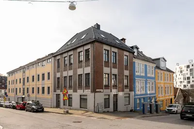 a building on the side of a street with parked cars at Central apartment building in Bergen