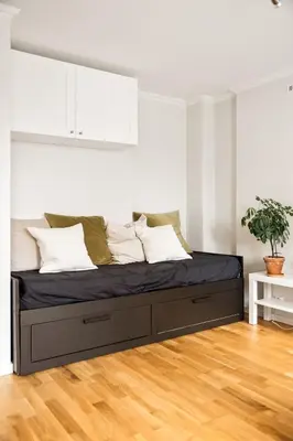 a bed in a room with a white wall at Appartment Bergen, Skansen in Bergen
