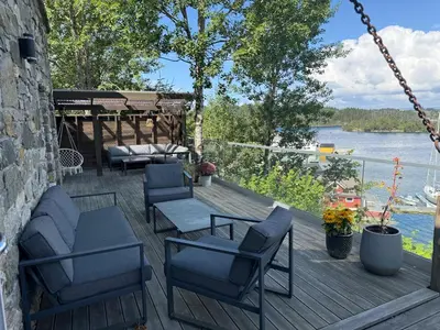 a porch with chairs and a swing and a view of the water at Haven Fortress in Lii