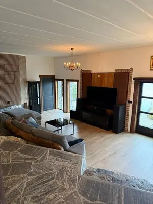a living room with a large couch in a room with a television at Haven Fortress in Lii