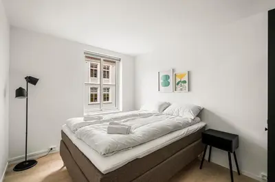a bed in a white room with a window at City Center, Light & Modern Apartment in Bergen