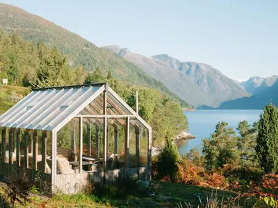 a greenhouse in the grass next to a lake at 2 person holiday home in Balestrand in Balestrand