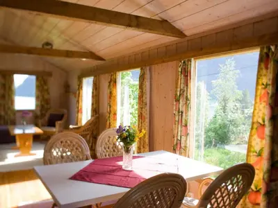 a table with chairs and a vase of flowers on it at 2 person holiday home in Balestrand in Balestrand