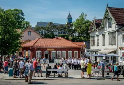 a crowd of people standing in the street in front of a building at Langesund brygge in Lii