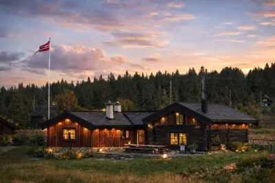 a log cabin with an american flag flying above it at Historical & exclusive cabin - Ski in-out - 18 people in Nord-Fron