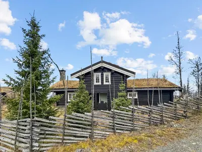 a black house with a fence in front of it at Exclusive cottage Jacuzzi View Ski in out in Aurdal