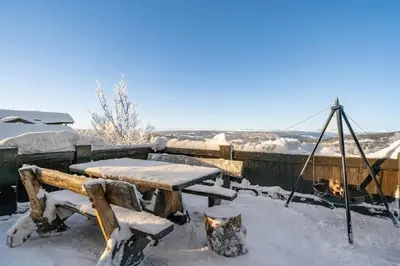 a picnic table covered in snow on a patio at Exclusive cottage Jacuzzi View Ski in out in Aurdal