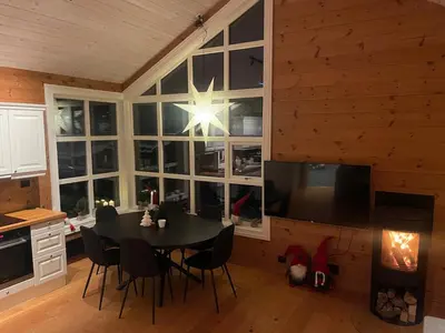 a dining room with a table and a large window at Velkommen til topp leilighet på Strandafjellet 2 soverom og hems in Stranda