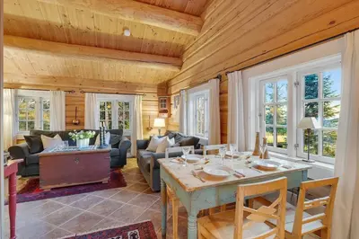a living room with a wooden ceiling and a table at Log cabin in Valdres Fireplace Sauna 1000 m above sea level in Aurdal