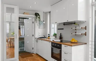 a kitchen with white cabinets and a wooden counter top at Modern and airy apartment in Bergen city center in Bergen