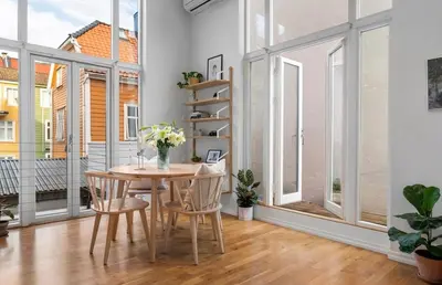a dining room with a table and chairs and windows at Modern and airy apartment in Bergen city center in Bergen