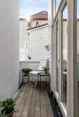 an outdoor balcony with a chair and a table at Modern and airy apartment in Bergen city center in Bergen