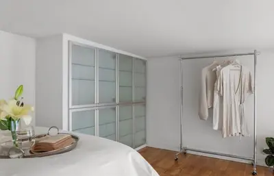 a white room with a bed and a closet at Modern and airy apartment in Bergen city center in Bergen