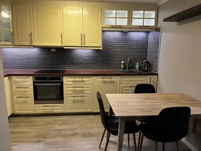 a kitchen with yellow cabinets and a wooden table at Apartment Stedjeåsen 70 in Sogndal
