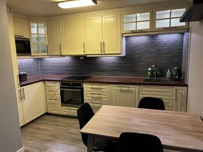 a kitchen with yellow cabinets and a wooden table at Apartment Stedjeåsen 70 in Sogndal