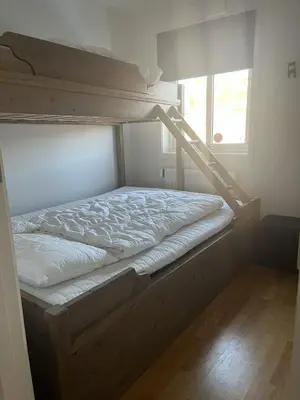 a bedroom with two bunk beds and a window at Romslig toppleilighet 134 kvm med balkong perfekt for firma og grupper in Beitostøl
