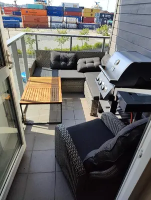 a patio with a couch and a grill on a balcony at Modern apartment in central Bergen in Bergen