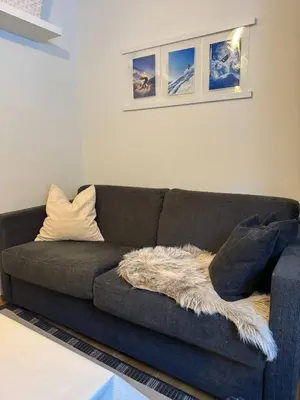 a living room with a couch with a blanket on it at Oppheim Mountain Resort - Pool, Sauna & Lake! in Vossevangen