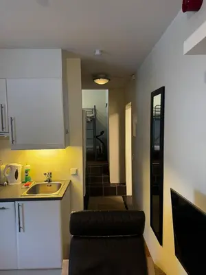 a kitchen with a sink and a chair in a room at Oppheim Mountain Resort - Pool, Sauna & Lake! in Vossevangen