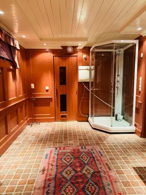 a bathroom with a glass shower and a tiled floor at Luxury cabin in the mountains, with sauna and steam shower in Geilo