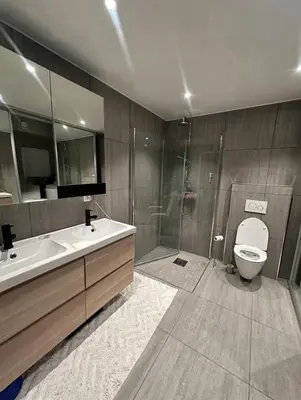 a bathroom with a toilet and a sink and a shower at Stor og moderne leilighet ved råstølen bybanestopp in Bergen