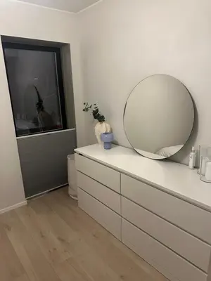 a white dresser with a mirror on top of it at Stor og moderne leilighet ved råstølen bybanestopp in Bergen