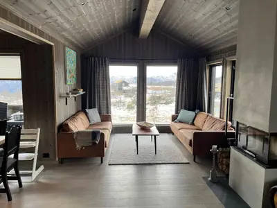 a living room with a couch and a table at Luxurious Cabin, 5 Bedrooms, Sauna Stunning View in Beitostøl