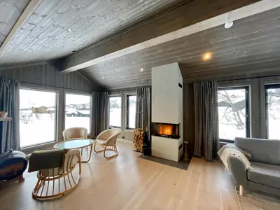 a living room with a couch a table and a fireplace at Luxurious Cabin, 5 Bedrooms, Sauna Stunning View in Beitostøl