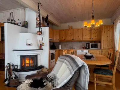 a kitchen with a fireplace and a table with a chair at Koselig Leilighet Med Flott Utsikt in Beitostøl