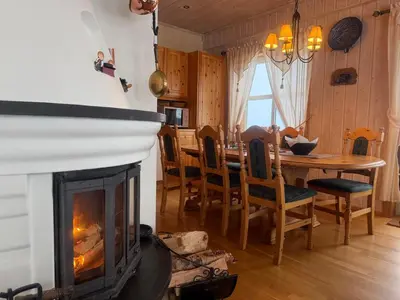 a living room with a fireplace and a dining room table at Koselig Leilighet Med Flott Utsikt in Beitostøl