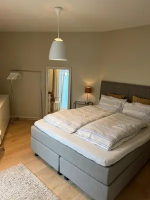 a large bed in a bedroom with a lamp at Leilighet 101 og 102 i Brunholmgata 9 in Ålesund