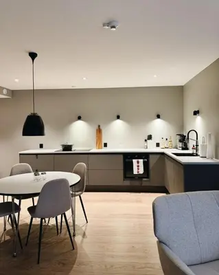 a kitchen and a living room with a table and chairs at Leilighet 101 og 102 i Brunholmgata 9 in Ålesund
