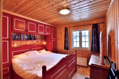 a bedroom with a large bed in a wooden room at Relax And Unwind At Slettero-A Cozy Family Getaway in Beitostøl