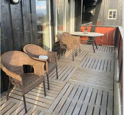 a patio with chairs and a table on a deck at Familievennlig Leilighet Med 7 Sengeplasser in Beitostøl