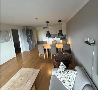 a living room and kitchen with a table and chairs at Familievennlig Leilighet Med 7 Sengeplasser in Beitostøl