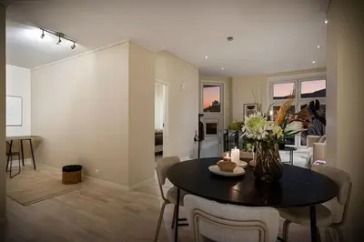a living room with a table with a vase of flowers at Nice apartment near the city center! in Bergen