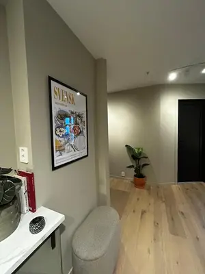 a living room with a chair and a picture on the wall at Fantastic village apartment in Bergen in Bergen